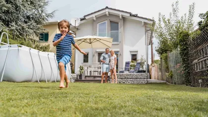 Enfant dans le jardin avec maison en fond