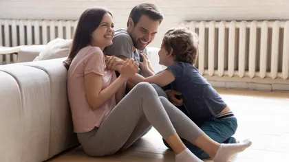 Famille heureuse près du chauffage de son salon