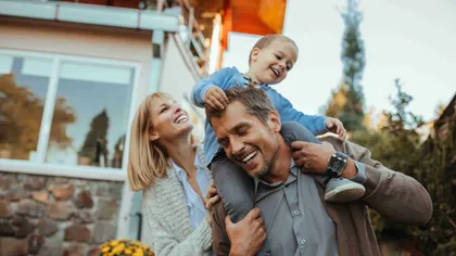Famille heureuse devant sa maison